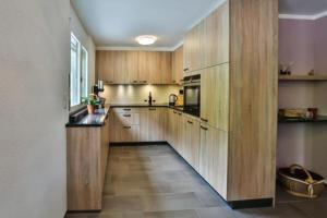 维尔德豪斯Wildhaus Weiherhof的大型厨房设有木制橱柜,地面铺有大地板