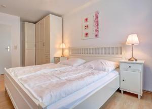 赛巴特班森Apartment Meereswoge的白色卧室配有一张大床和两盏灯。