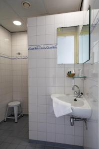 Twello餐厅酒馆宾馆的白色瓷砖浴室设有水槽和镜子