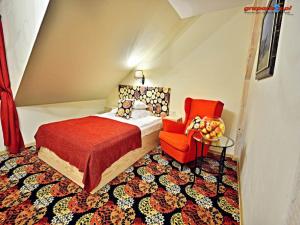 比得哥什Karczma Rzym Bydgoszcz S5的一间卧室配有一张床和一张红色椅子