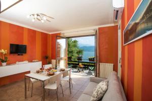 巴韦诺Casa Vacanze La Nautica的客厅设有橙色墙壁和桌椅