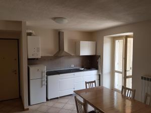 瓦拉洛residenza la roggia的厨房配有白色橱柜和一张桌子