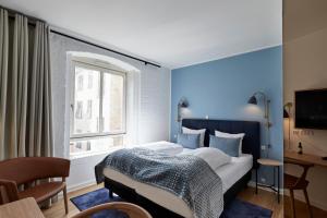 哥本哈根哥本哈根斯特瑞德酒店的一间卧室设有一张蓝色墙壁的大床