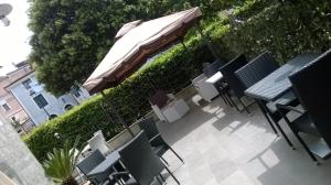 罗通达Hotel Sirio的一个带桌椅和遮阳伞的庭院