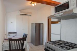 斯普利特Prime Location Penthouse apt with a large terrace的厨房配有不锈钢冰箱和桌椅