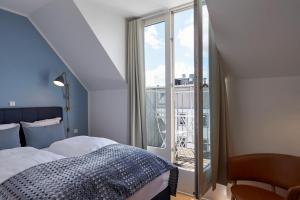 哥本哈根哥本哈根斯特瑞德酒店的一间卧室设有一张床和一个大窗户