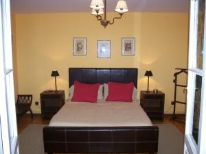 Tamariz de CamposQuinta del Canal的一间卧室配有一张带红色枕头的大床