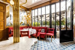 巴黎堡夫库罗讷餐厅酒店的一间带桌子和红色椅子的用餐室
