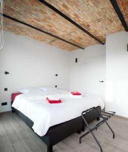 佐内贝克gastenverblijf 't Baertshof的卧室配有一张大白色的红色把手床