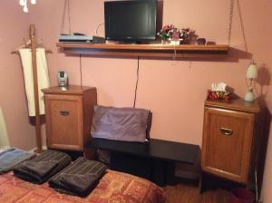 罗登露露和卢丹之家旅馆的一间卧室配有一张床、一张书桌和一台电视。