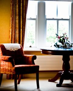 韦斯特波特阿德莫尔乡间别墅酒店的一间带椅子和桌子的房间以及窗户