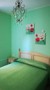 斯培西亚Locanda del Golfo的一间卧室配有一张绿色的床和吊灯。