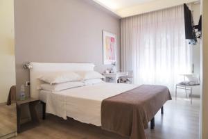 罗马高级客房精英酒店的卧室设有一张白色大床和一扇窗户。