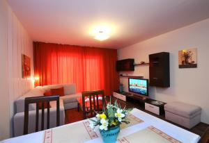 Oberaichwald阿尔卑斯亚德里亚公寓酒店的客厅配有沙发和鲜花桌