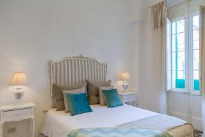 法萨诺Dimore del Faso的一间卧室配有白色床和蓝色枕头