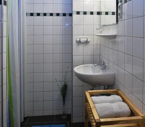 费尔特拉科什Várfal Vendégház的浴室配有盥洗盆、镜子和毛巾