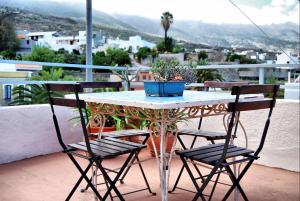 圭马尔Casa Tesalia的阳台上的桌子、两把椅子和盆栽植物