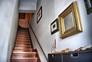 圭马尔Casa Tesalia的走廊上设有楼梯,墙上挂着金色照片
