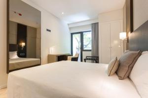 里斯本Hotel Capital Lisboa的卧室设有一张白色大床和一扇窗户。