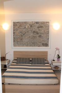 蒙特罗索阿尔马雷Marianna Quiet Rooms的卧室内的一张床铺,墙上有绘画作品