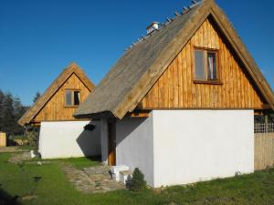 WerbliniaDomki przy lesie的茅草屋顶和车库的房子