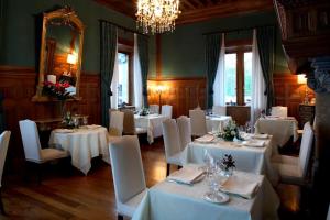 戈特赫斯阿特亚加Hotel Castillo de Arteaga的一间配备有白色桌椅和吊灯的餐厅