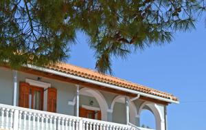 Ágios NikólaosPine tree Apartment & sunset的白色的房子,有屋顶和树