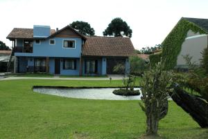 格拉玛多Residencial Aconchego do Lago的院子里有池塘的房子
