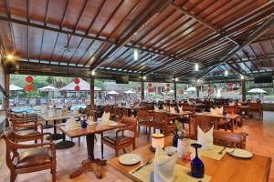 勒吉安The Jayakarta Bali Beach Resort的一间带木桌椅的餐厅和一间大房间