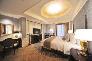 上海上海大酒店 的酒店客房配有一张床、一张书桌和一台电视。