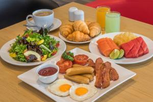 暖武里府曼谷冲击宜必思酒店 的一张桌子,上面有三盘早餐食品