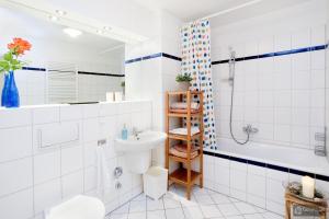 柏林Berlin Center的浴室配有盥洗盆、卫生间和浴缸。