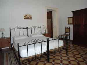 莱乌卡Casa Tipica的一间卧室配有一张带白色床单的大床