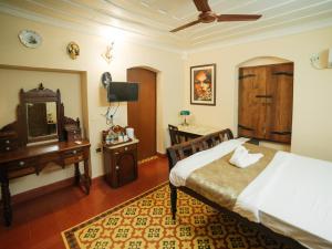 巴姆博利姆Casa Menezes - A Heritage Goan Homestay的一间卧室配有一张床、一张书桌和一面镜子