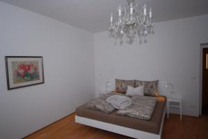 泰尔拉诺Torilan的白色的客房配有一张床和吊灯