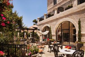 耶路撒冷Villa Brown Jerusalem, a member of Brown Hotels的户外庭院设有桌椅和鲜花