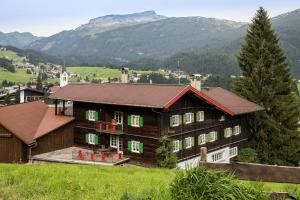 里茨勒恩瓦尔泽家旅馆的一座带绿色窗户和山脉的大型木屋