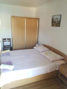 布尔纳Bleus Apartments的一间卧室配有一张大床和木制床头板