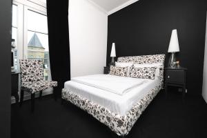 莱茵河畔林茨布奇纳克酒店的黑白卧室配有床和椅子