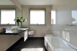 阿利坎特欧洲之星光明之城酒店的带浴缸、盥洗盆和卫生间的浴室