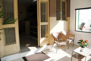恩布Hotel Vale das Artes的门廊配有两把椅子和一张桌子,门