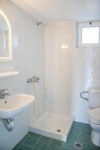 罗达奇诺Kleanthis Apartments的白色的浴室设有水槽和卫生间。