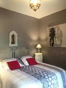 阿卡雄La Maison de Lilly的一间卧室配有一张大床和两个红色枕头