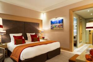多维尔高尔夫巴里亚酒店的酒店客房配有一张带红色枕头的大床