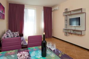圣弗拉斯Mars Apartments in Complex Shipka的客厅配有一张桌子,并提供一瓶葡萄酒
