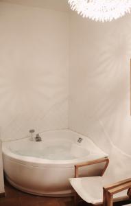 塞斯特雷庞克塔酒店的配有吊灯的浴室内的白色浴缸