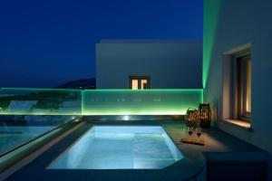 卡特瑞杜斯Ikies Santo Filoxenia Apartments的一座晚上设有游泳池的房子