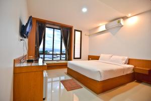 帕夭Sabuy Best Hotel Phayao的一间卧室配有一张床、一台电视和一个窗口