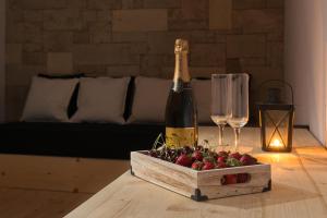 罗德镇老城感官精品酒店 的一瓶香槟和一盒草莓放在桌子上