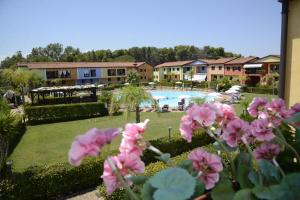 波利科罗I Giardini Elisei的享有带游泳池和粉红色鲜花的度假村景色